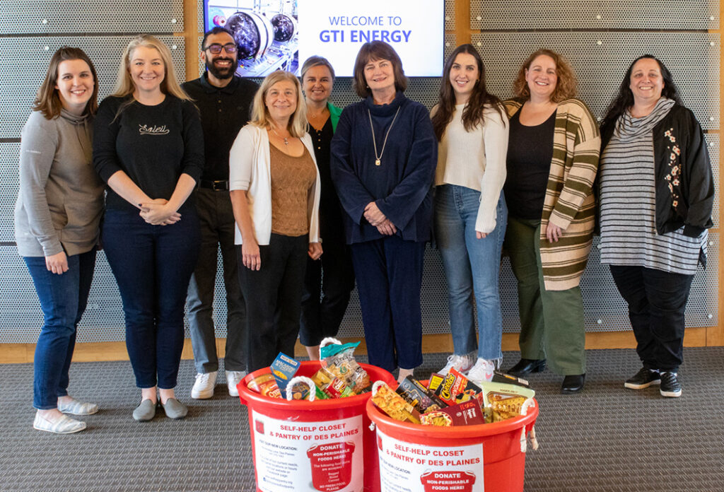 GTI Energy employees standing behind the Food Drive bins