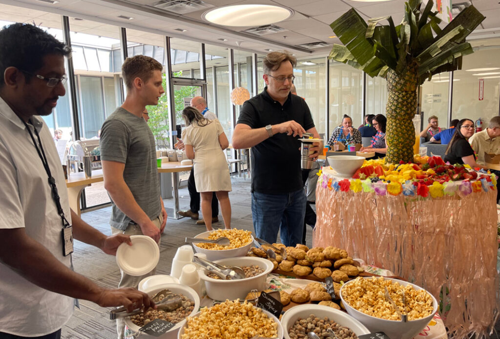 GTI Energy employees attending our luau looking at the tables of food